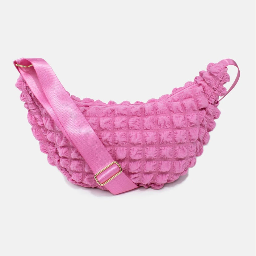 Kind Bag crossbody bag in bold pink waffle texture – playful and vibrant design made from recycled materials