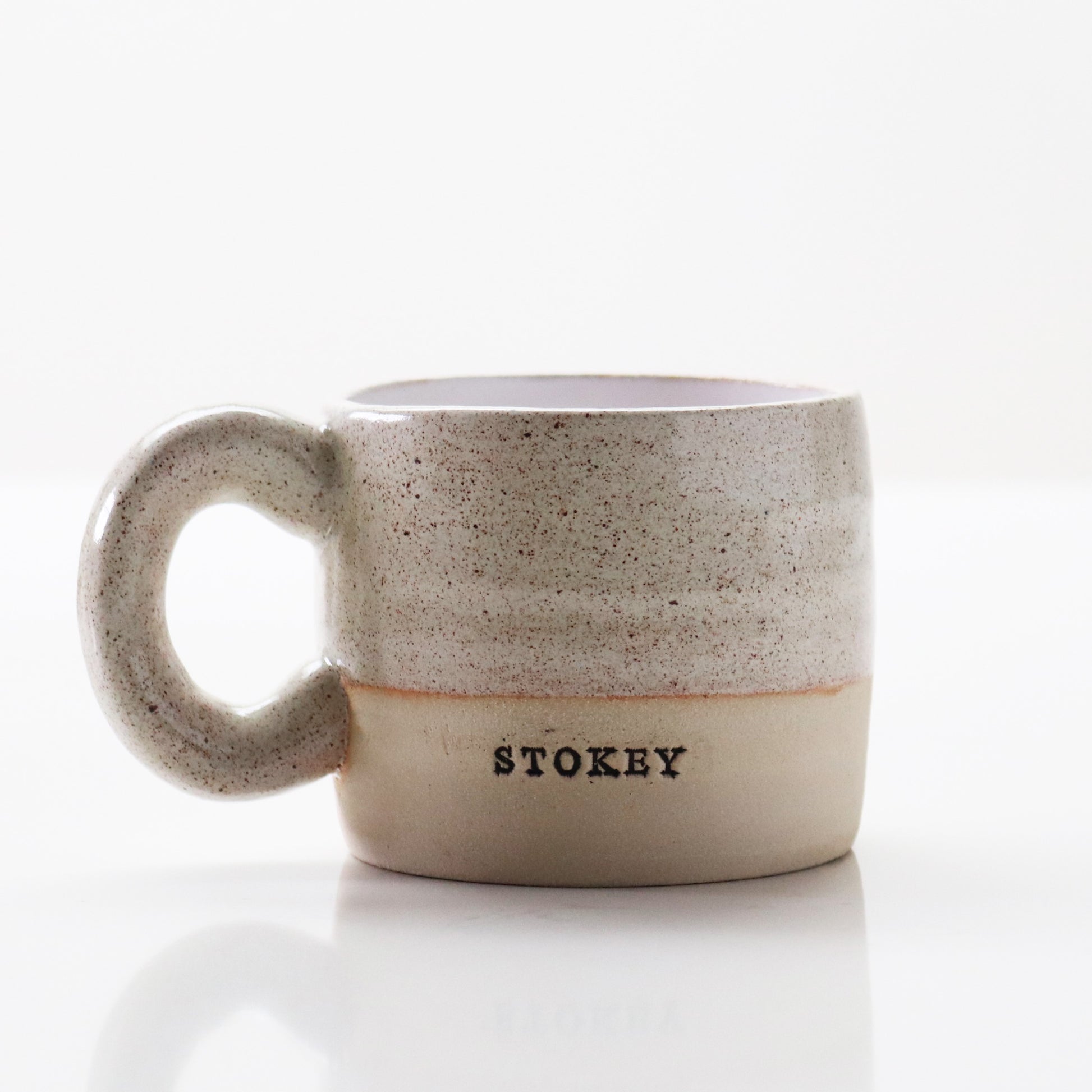 Grey speckled mug stamped ‘Stokey’ by Lesley McShea