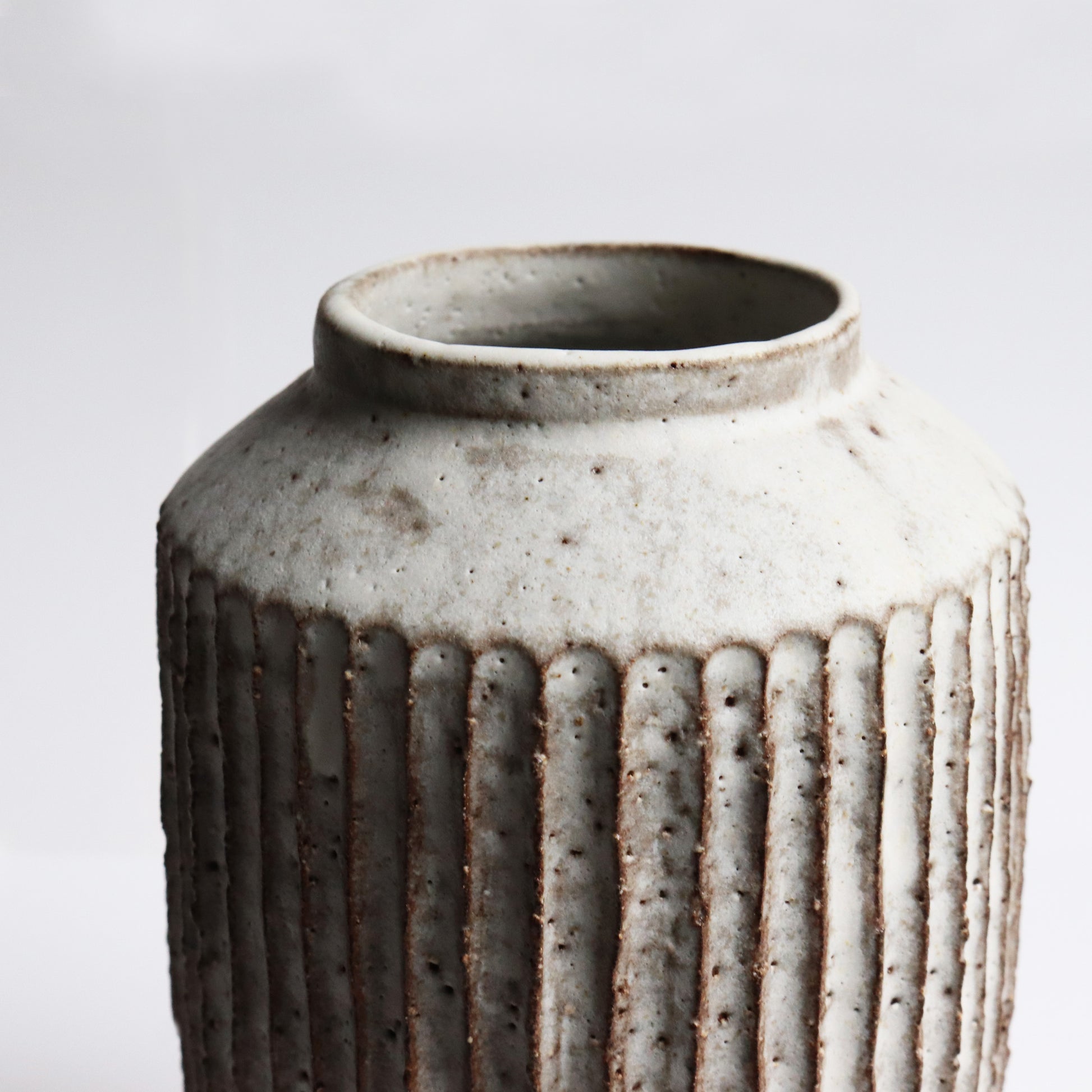 Handcrafted ceramic fluted vase by Janne Cornish in chalky white stoneware with carved ridges – made in Hackney