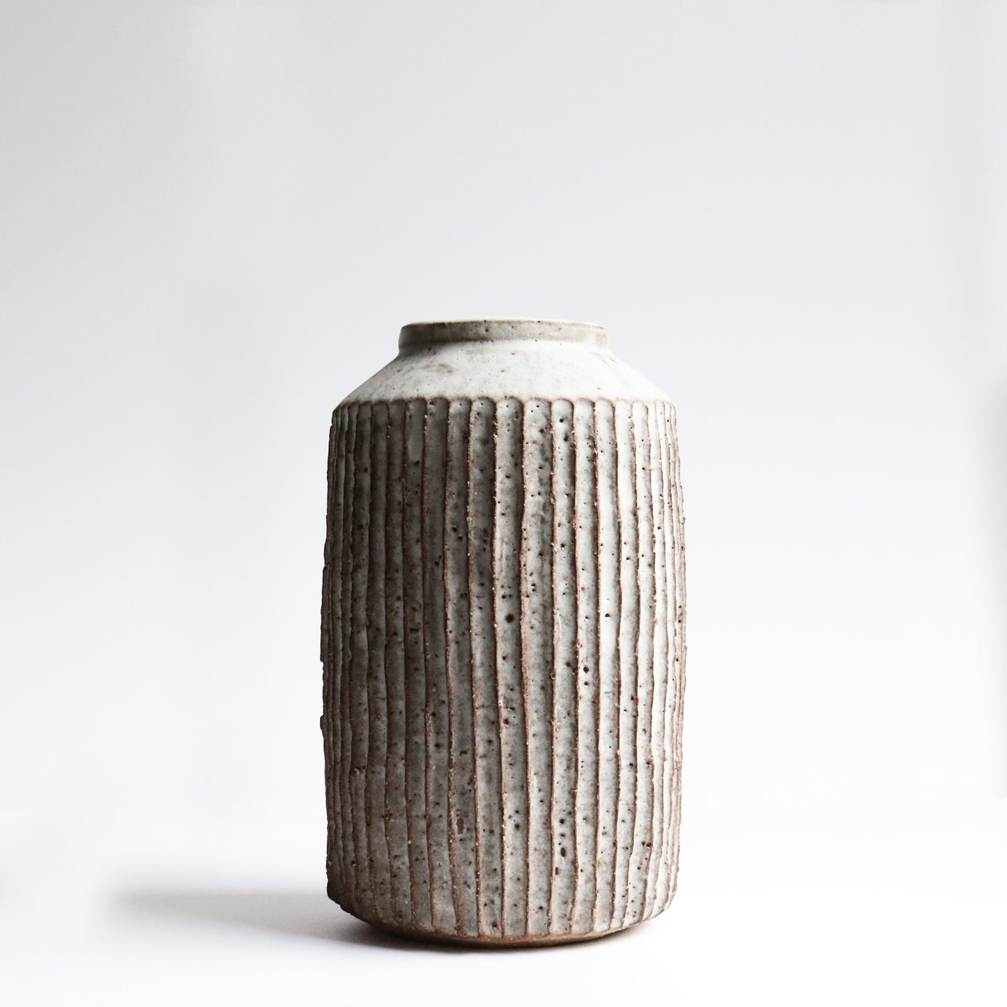 Handcrafted fluted vase by Janne Cornish in chalky white stoneware with carved ridges – made in Hackney
