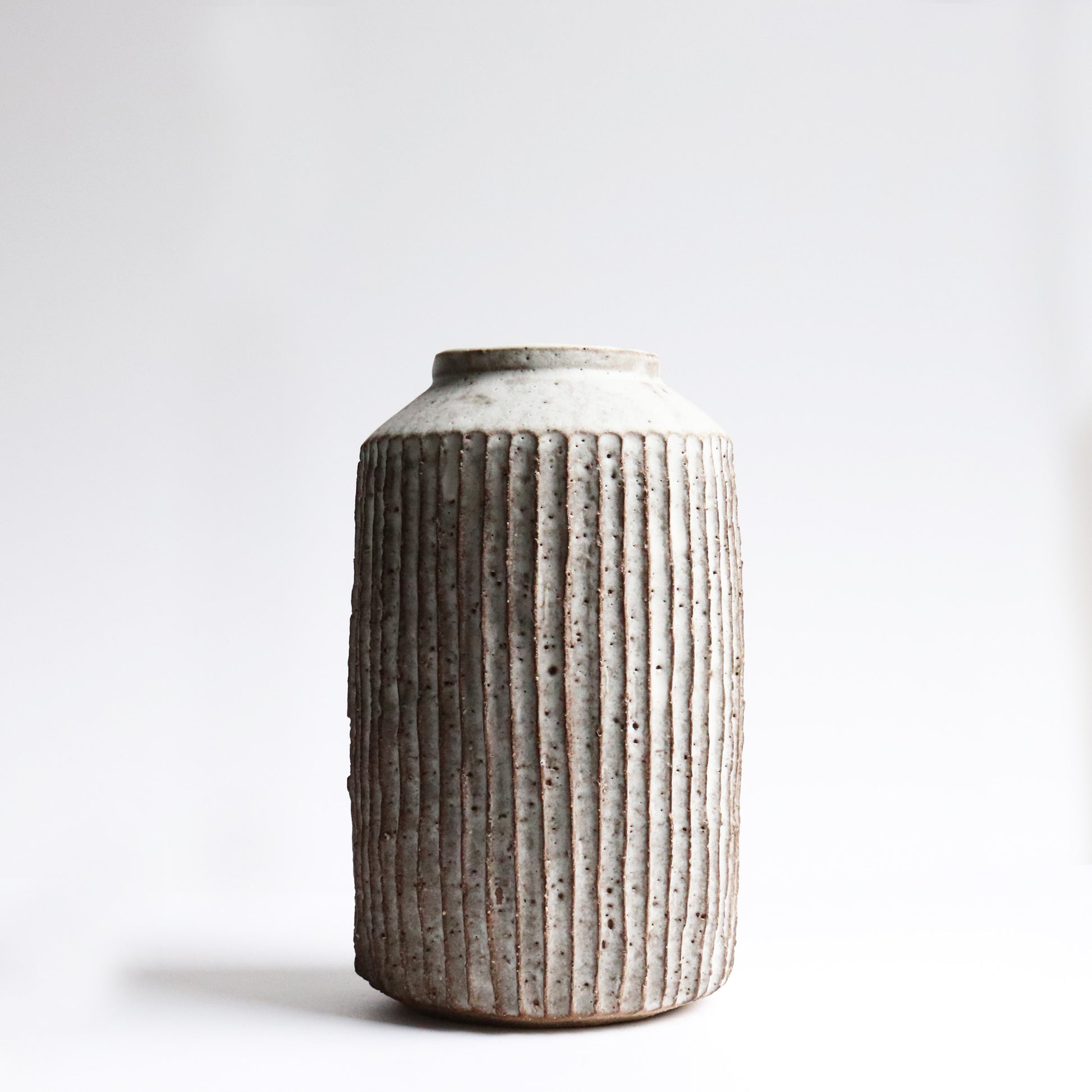 Handcrafted fluted vase by Janne Cornish in chalky white stoneware with carved ridges – made in Hackney
